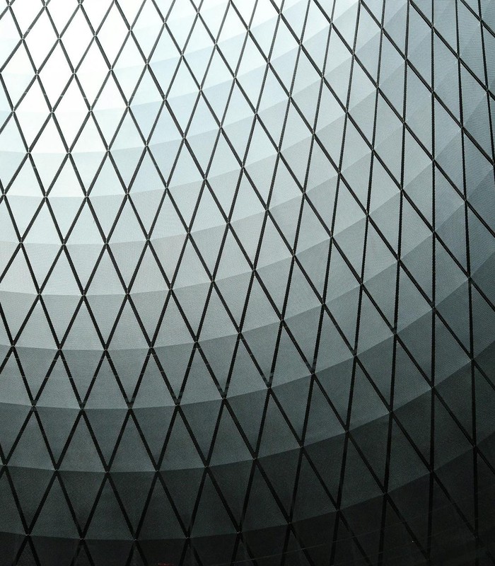 Abstract view of a geometric dome ceiling with a diamond pattern in black and white tones.